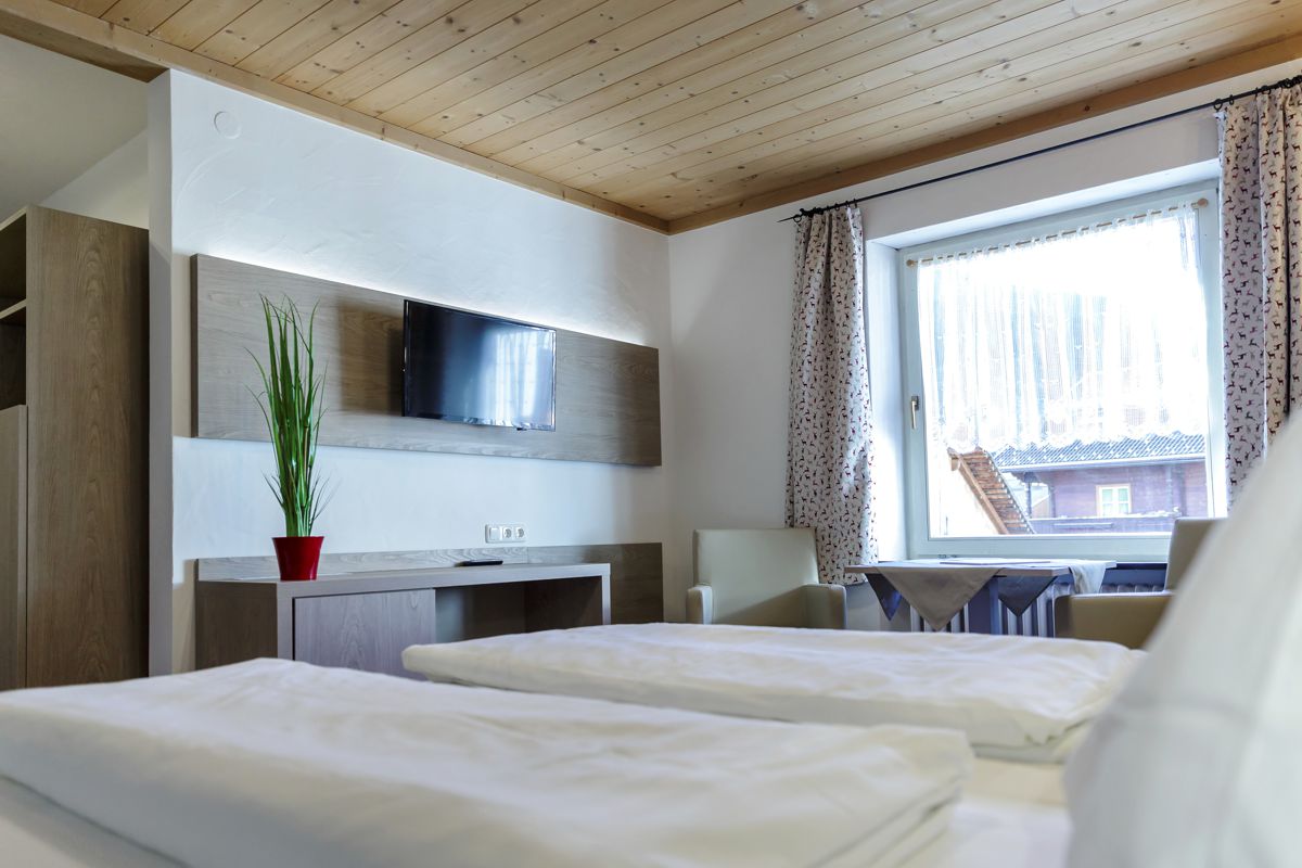 Doppelzimmer im Hotel Bergland mit Bett, Sitzbereich und Fenster